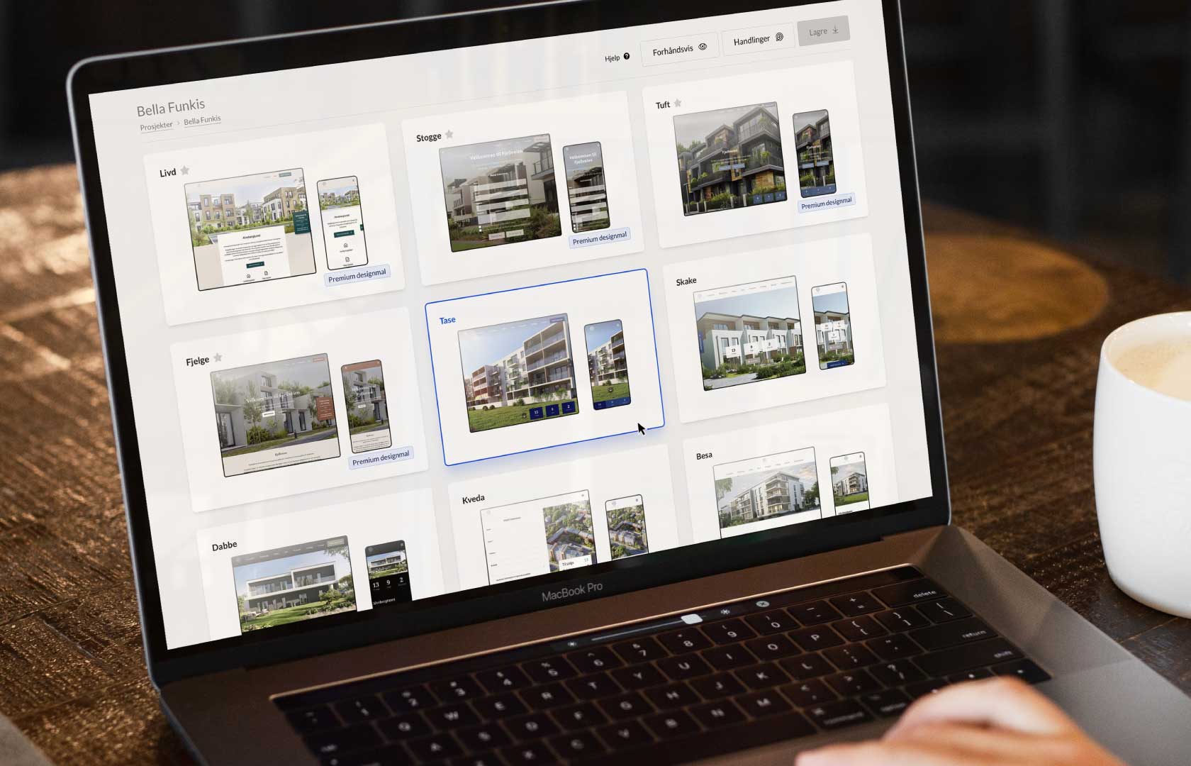 En skärmbild av en bärbar dator som visar publiceringslösningen Kvass. Webbplatsen visar olika designmallar för fastighetsprojekt. Användaren kan välja mellan flera olika layoutalternativ för att presentera bostadsprojektet, med bilder av moderna bostadsbyggnader. Varje mall har en förhandsgranskning av hur projektet kommer att se ut på både dator och mobil. På skärmen finns även knappar för att få hjälp, förhandsgranska och spara ändringar. En kaffekopp syns bredvid datorn